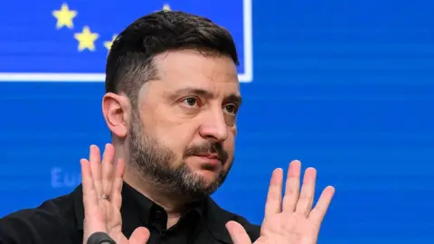 Ukraine's President Volodymyr Zelensky gestures as he speaks during a press conference as part of the European Council meeting in Brussels on December 18, 2025