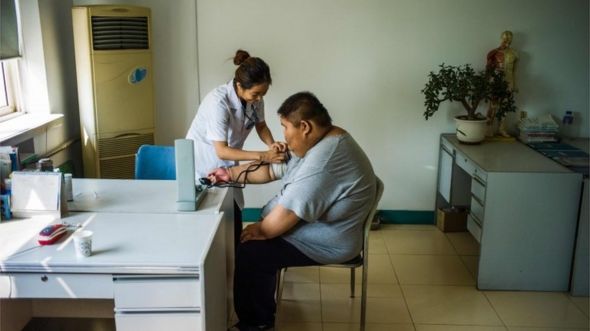 This file photo taken on May 25, 2015 shows a nurse taking the blood pressure of an overweight youth during his acupuncture and exercise treatment at the Aimin (Love the People) Fat Reduction Hospital in the northern port city of Tianjin.