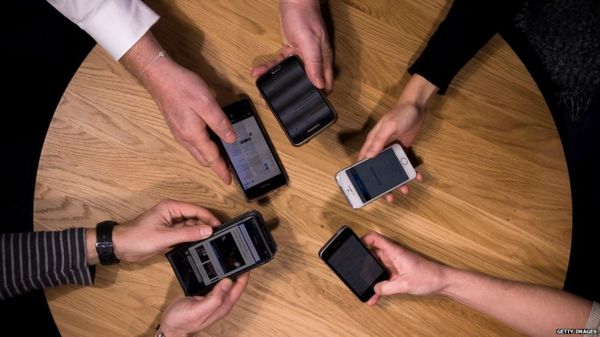 Hands and phones around a round table