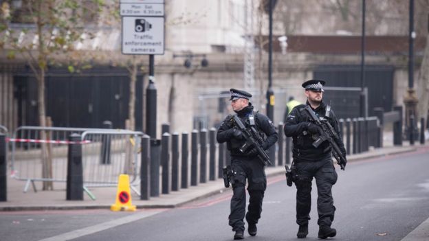Armed police officers walk in central London, ahead of the New Year celebrations, as thousands of police officers will provide a protective ring around the city