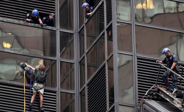 A man scales the all-glass facade of Trump Tower