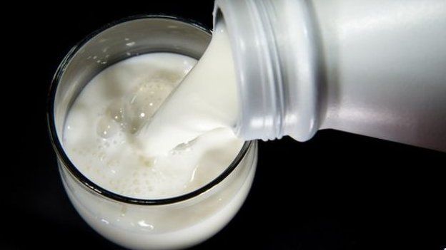 Milk being poured from a bottle into a glass
