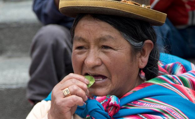 Mujer masticando hoja de coca.