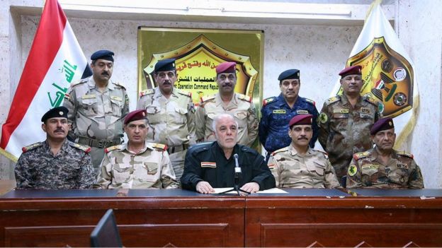 El primer ministro iraquí Haider al-Abadi, al centro, rodeado por militares al hacer el anuncio de la ofensiva en Mosul.