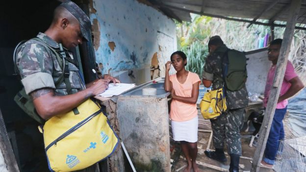Brazilian soldiers inspect a home in an attempt to eradicate the larvae of the mosquito which causes the Zika virus.