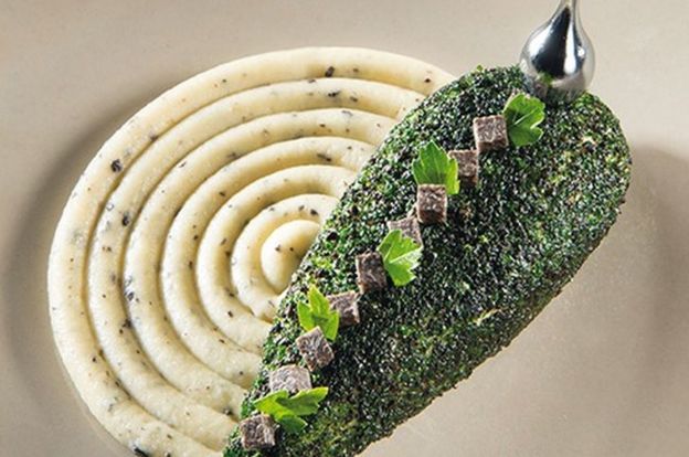 Wing of pheasant accompanied by black truffle potatoes and green leaves