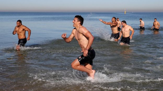 Hombres bañandose en la playa