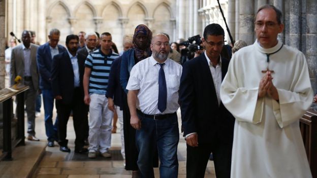 Muslim faithfuls walk behind a religious man as they attend a Mass in tribute to priest Jacques Hamel in the Rouen Cathedral on July 31, 2016