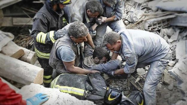 State forestry service photo of rescue workers pulling survivor from rubble