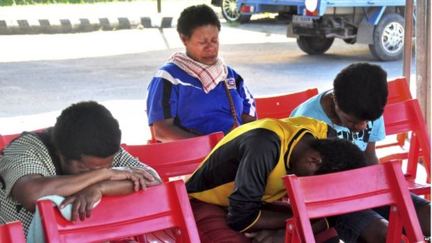 Relatives of passengers on the missing Trigana Air Service flight sit at Sentani airport in Jayapura, Papua province, Indonesia, Monday, 17 August 2015.