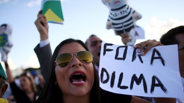 An anti-government demonstrator shouts slogans against a supporter of Brazil's President Rousseff