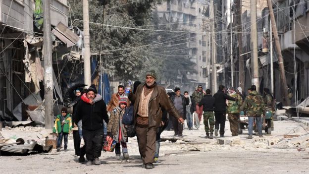 Syrian residents flee violence in Aleppo's eastern al-Saliheen neighbourhood on December 12, 2016 after regime troops retook the area from rebel fighters.