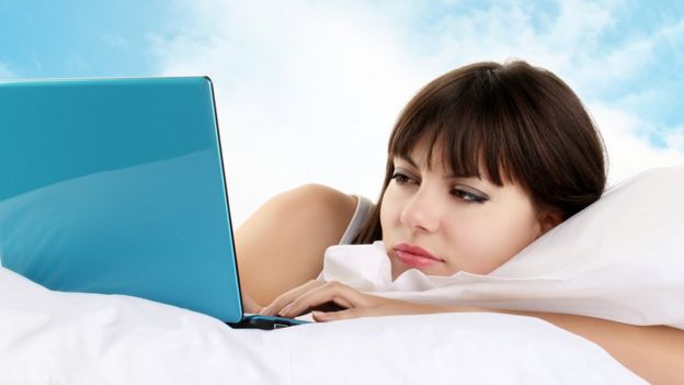 Mujer con la computadora portátil a punto de quedarse dormida