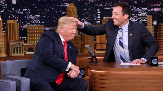 Late night show host Jimmy Fallon musses Mr Trump's hair