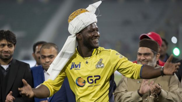 Former West Indies captain Darren Sammy gestures wearing a traditional turban at Gaddafi stadium in Lahore, Pakistan, Sunday, March 5, 2017.