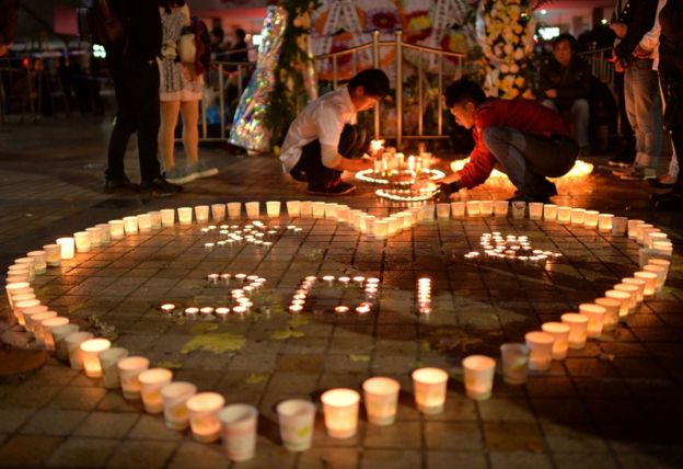 This picture taken on 2 March 2014 shows Chinese mourners lighting candles at the scene of the terror attack at the main train station in Kunming, southwest China's Yunnan Province.