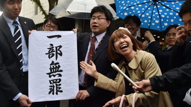 Japanese artist Megumi Igarashi (2nd R) and her lawyers pose with a sign reading 