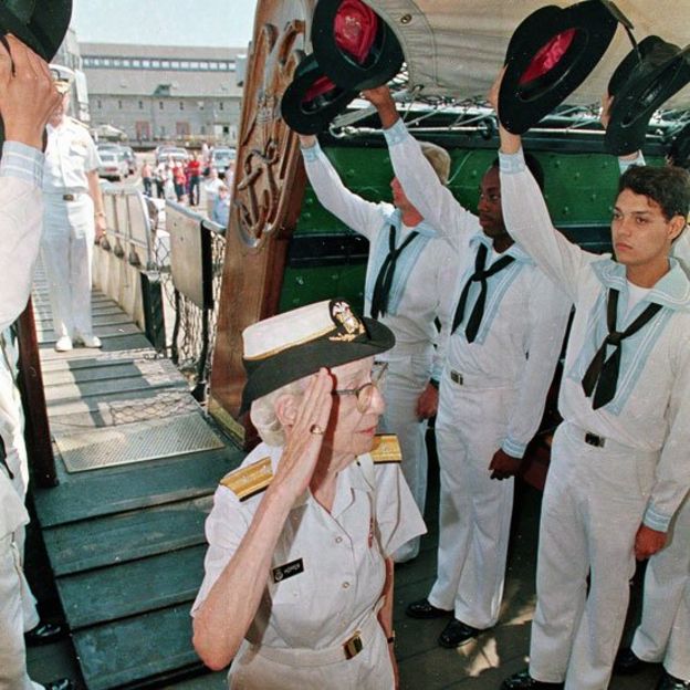 Grace Hopper fazendo a saudação militar a um grupo de cadetes navais
