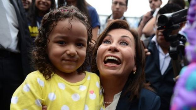 Sandra Torres smiles as she pose for photos with a child after casting her vote in Guatemala City on 25 October, 2015.