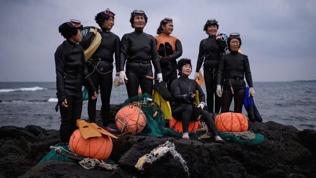 In a photo taken on November 6, 2015 a group of 'Haenyeo' pose for photographers as they perform a demonstration during a media event organised by the Foreign Press Center, on South Korea's southern island of Jeju.