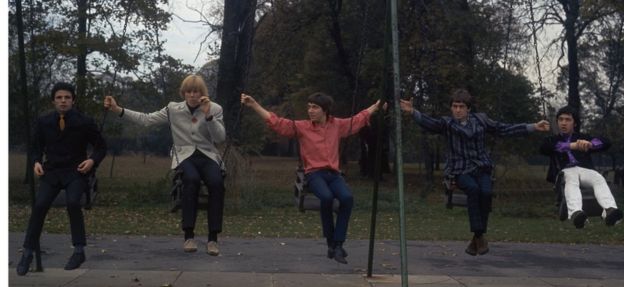 The band, pictured on park swings in 1966