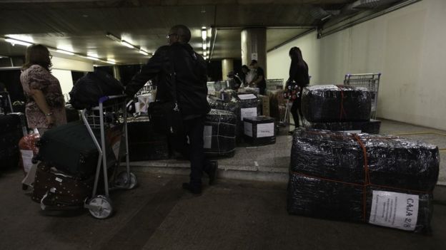 Médicos cubanos com malas e objetos embalados em aeroporto