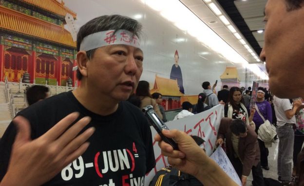 Lee Cheuk-yan talking to a reporter at a protest