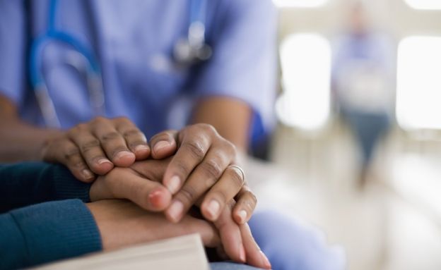 Doctor holding patients hands