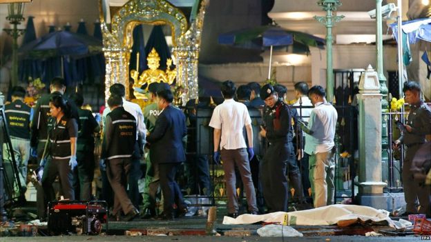 A covered body of victim is seen while Thai police officers inspect a blast scene after an explosion near Erawan Shrine in Bangkok, Thailand - 17 August 2015