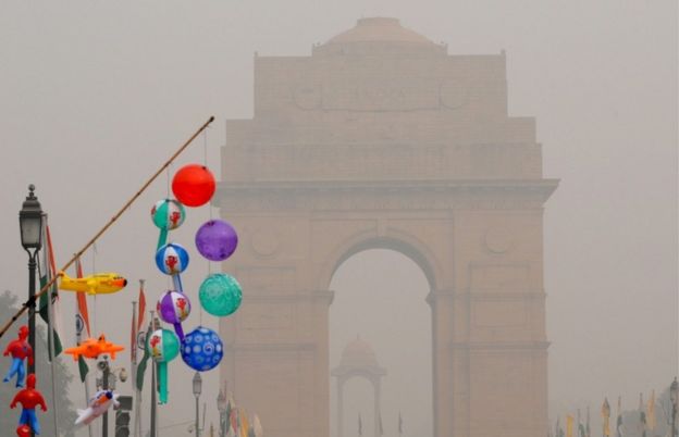 Inflatable toys are displayed for sale near the India Gate, seen engulfed in smog in Delhi on 5 November,2016.