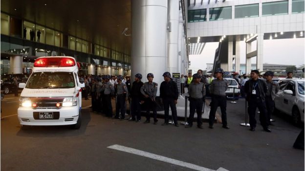 Police stand guard as an ambulance that carries the body of lawyer Ko Ni drive pass the scene of a shooting near the entrance of the Yangon International Airport, Yangon, Myanmar, 29 January 2017