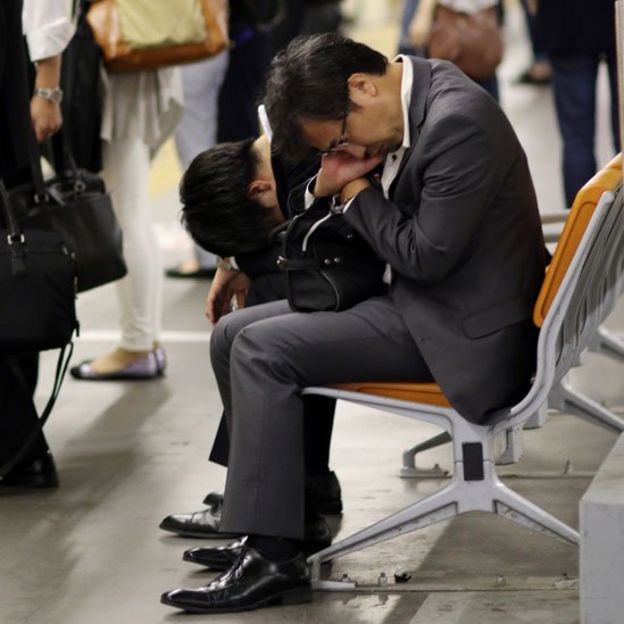 Ejecutivo dormido en un banco en una estación de metro