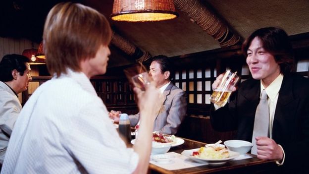 Trabajadores japoneses comiendo y bebiendo en un restaurant