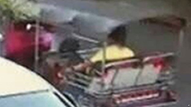 An image released by Thai police of a suspect wearing a yellow T-shirt sitting in a tuk-tuk near the Erewan Shrine