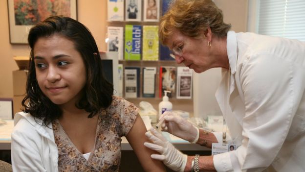 Médica vacuna a joven.