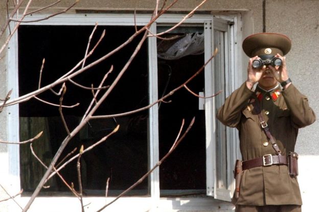 A North Korean soldier looks at the southern side through field glasses at the border village of Panmunjom, north of Seoul, Wednesday, 13 April 2005