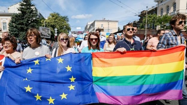 Participants carry rainbow and European Union flags during the Gay Pride parade in Kiev, Ukraine, 12 June 2016