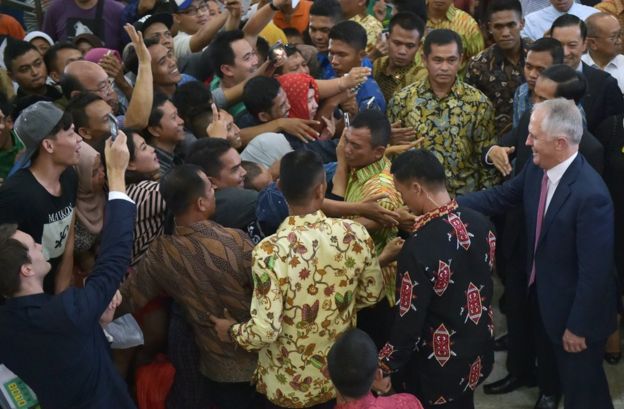 Indonesians rush to shake hands with Australia's Prime Minister Malcolm Turnbull (R) and Indonesian President Joko Widodo (obscured) as they visit the Tanah Abang retail market in Jakarta on November 12, 2015. Turnbull made his first visit to Indonesia since taking power, seeking to repair a key relationship strained by repeated crises under his conservative predecessor. AFP PHOTO / ADEK BERRY / POOL (Photo credit should read ADEK BERRY/AFP/Getty Images)
