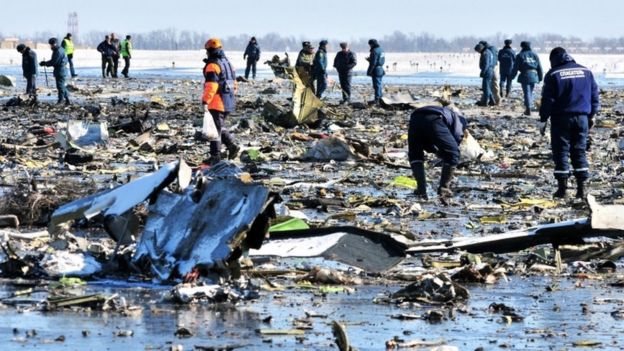 Russian investigators and policemen inspect the crash site of a Boeing 737-800 FlyDubai plane at Rostov-on-Don airport