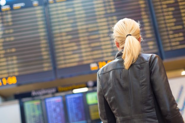 Mujer mirando pantalla en un aeropuerto