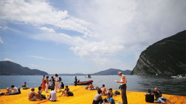 People sit on the Floating Piers installation by artist Christo 18/06/2016