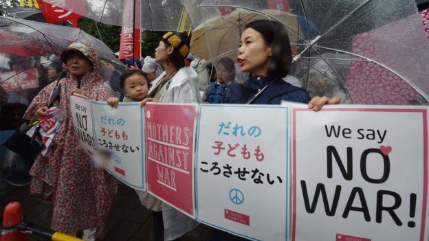 Young mothers carrying children and umbrellas, protesting against the security bills on Thursday