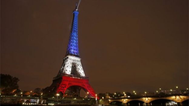 The Eiffel Tower is lit with the blue, white and red colours of the French flag in Paris