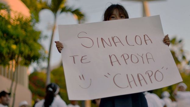 Una niña sostiene una pancarta que dice: 
