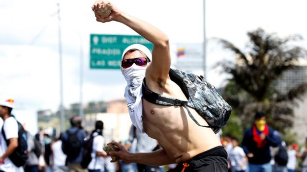 Un manifestante lanza una piedra
