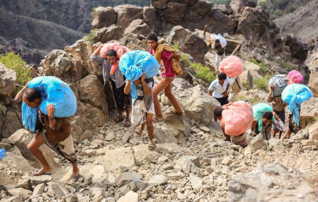 People carrying goods over the mountains