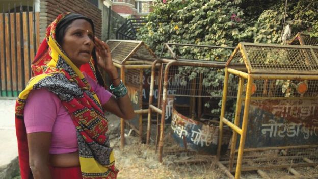 The mother of one of the victims in front of Pandher's house