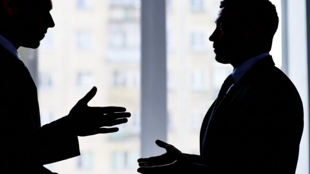 Two men in suits arguing