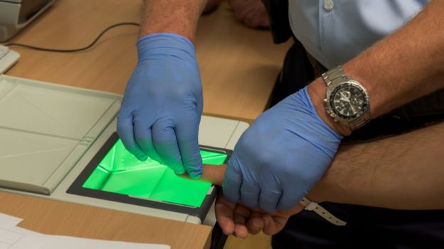 German police taking a migrant's fingerprints, 15 Jul 15