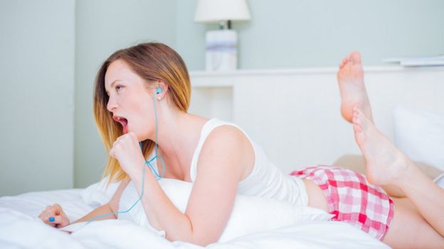 girl with phone yawning